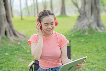 Woman uses iPad to listen to music outdoors