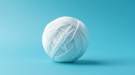 Vibrant white yarn ball isolated on blue background.