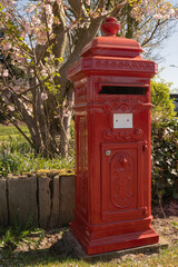 A single red mailbox in an empty street, representing the vanishing culture of personal letters and the shift to digital messaging.