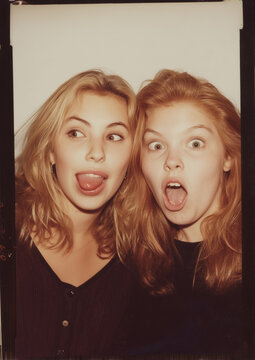 vintage photo booth film of two blond female friends pulling silly faces in 80s - 90s in color