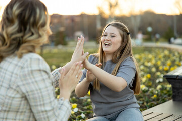 A mother and daughter share laughter and play in a vibrant park, capturing the essence of joy and connection in nature.