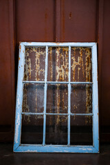 rustic light blue multi-paned window frame against rusty background