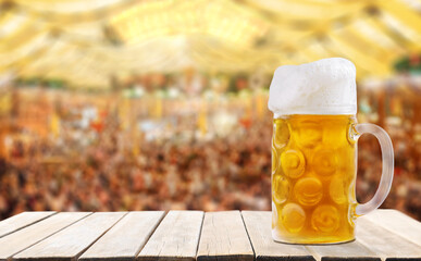 Mug of beer on wooden table on tent beer background. Oktoberfest, beer festival © Nitr