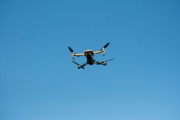 Flying Drone in Clear Blue Sky – Front View of Quadrocopter in Flight