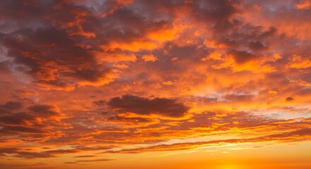 Fototapeta premium Dramatic sunset sky ablaze with fiery orange and dark clouds formations