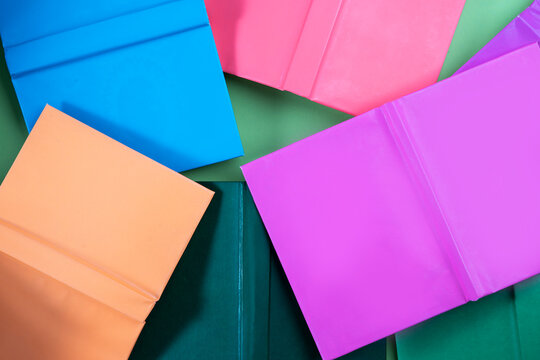 Book background. Many colorful books create texture for design. Concept of library, children's literature, textbooks for teenagers.