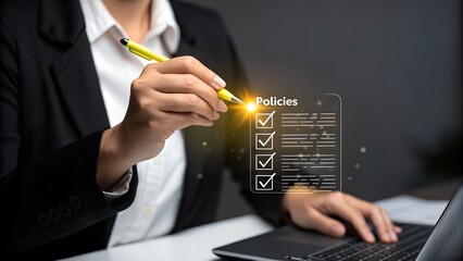 Close-up of a person in a black blazer reviewing a digital checklist of policies on a laptop screen.