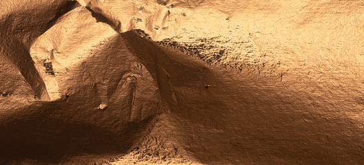 Bronze metallic foil texture with a crumpled, rough surface. Shiny, dark background with rich shadows and dramatic glow for a vintage, industrial look. Luxury wrapping material with burnished detail.