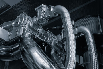 Modern diesel engine generator with shiny stainless steel pipes and mechanisms, bottom up view