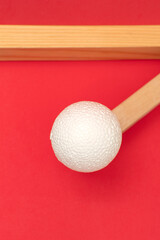 Still life with wooden blocks and a a plastic foam ball on red background