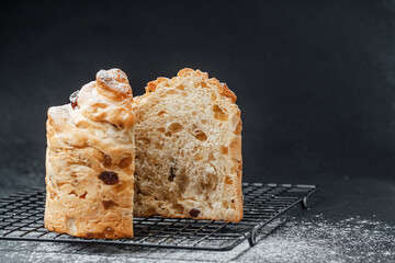 Freshly baked bread loaf with a slice cut on a black cooling rack
