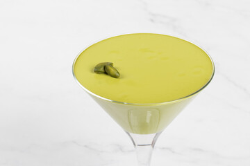 Pistachio cream jelly in a martini glass. Light background. Close-up