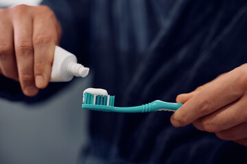 Close up of man using toothbrush in bathroom.