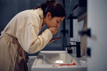 Young woman during her morning routine in bathroom.