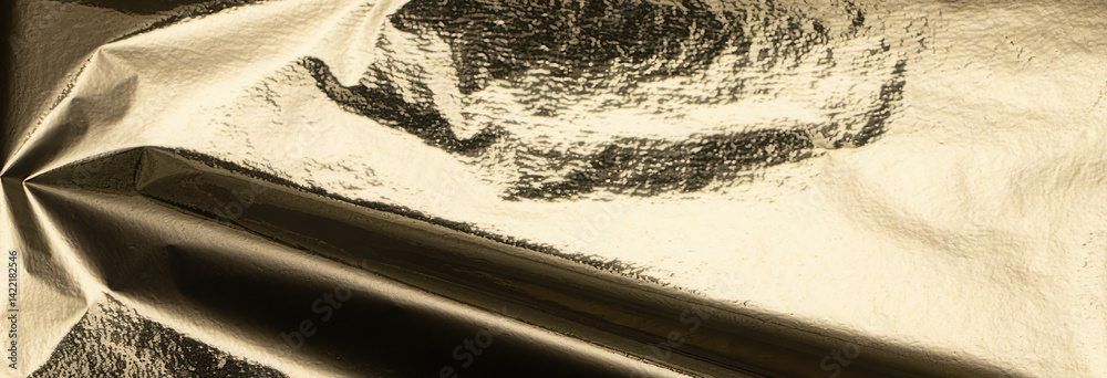 Poster gold metallic foil texture with a crumpled, folded surface. shiny, glossy material reflecting light 