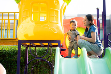 While in vacation at home, a mother engages in activities with little kid in the park