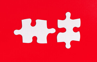 Obraz premium Puzzle pieces with a mismatch against a bold red background, symbolizing disconnect and the challenge of problem-solving. The incomplete fit represents the struggle in decision-making, contrast, and.