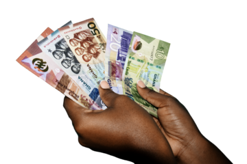Black african hands holding various Ghanaian cedi notes over transparent background. closeup of Hands holding Ghana paper currencies. three quarter view
