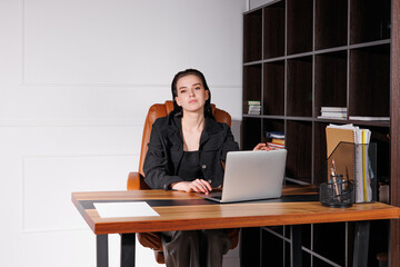 Young woman working diligently at a sleek desk in a modern office during daylight hours