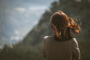 Mulher de costas olhando o horizonte nas montanhas