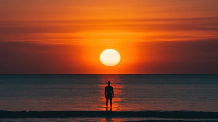 A lone person watches the beautiful bright sun over ocean water