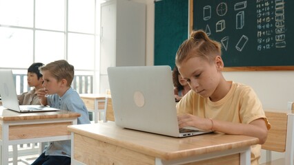 Smart caucasian boy using laptop to generated AI by coding engineering prompt. Diverse student learning or studying programing system while attending in STEM technology class. Technology. Pedagogy.