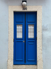 Fototapeta premium Bright blue door with number 192 on a stone frame