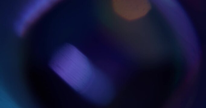 Flare glare. Blur light texture. Defocused purple yellow green color lens sparkle flicker on abstract abstract art dark black background.