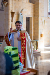 Catholic priest blesses parishioners with holy water on Easter Vigil. High quality photo