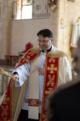 Catholic priest blesses parishioners with holy water on Easter Vigil. High quality photo