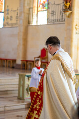 Naklejka premium Catholic priest blesses parishioners with holy water on Easter Vigil. High quality photo