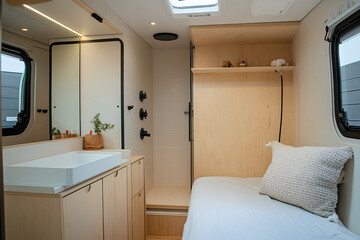 Fototapeta premium A minimalist shot of the small, efficient bathroom inside the trailer, showing a tiny shower, sink, and mirror.