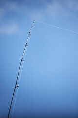 Long fishing rod against the sky. Close-up.