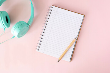 Notebook on the table. Blank notebook with space for a message. Pens, headphones