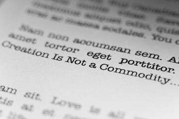 Creation is not a commodity. Christian text printed on a page. A piece of paper with a phrase written in retro typewriter font.