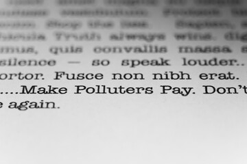 Make polluters pay. Text printed on a page. A piece of paper with a phrase written in retro...