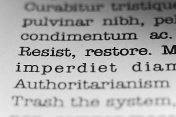 Obraz premium Resist, Restore. Text printed on a page. A piece of paper with a phrase written in retro typewriter font.
