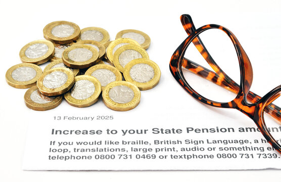 Close up view of a letter about an increase the the State Pension in the UK, with one poind coins and a pair of reading glasses. No people.