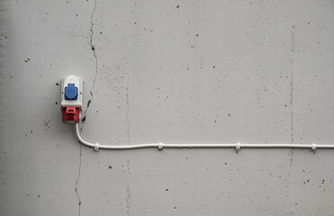 Electrical socket mounted on concrete wall.