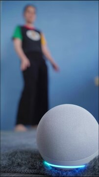 Smart home virtual assistant emitting cyan light, playing music while woman dancing joyfully, embodying modern digital lifestyle and entertainment technology