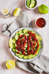 Delicious cucumbers with chili pepper and lime on a plate on the table top and vertical view