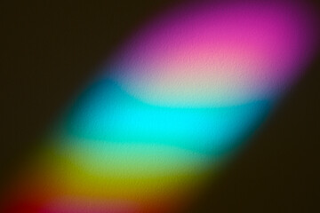 Soft focus rainbow neon grain blur texture wall with prism refraction. Light and shadow smoke abstract gradient rays background.