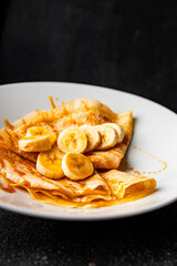 Crepes banana syrup pancakes breakfast dish dessert organic product fresh tasty gourmet food background on the table rustic food top view copy space