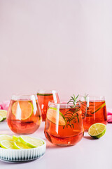 Alcoholic cocktail pink negroni with lime in glasses on table vertical view