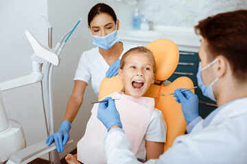 Work of professional doctor and pediatric dentist in modern clinic with equipment. Millennial man...