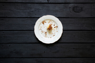 Easter cake leftovers and crumbs in a plate on a dark wooden table after the holiday, eaten