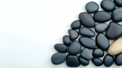 Zen-like Arrangement of Polished Black and Beige River Stones on White Background