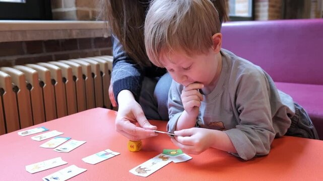 Engaging child learning activity with cards and dice at a cozy indoor space