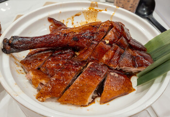 A portion of chopped Chinese style roast goose on a plate served with a delicious dark sweet soy...