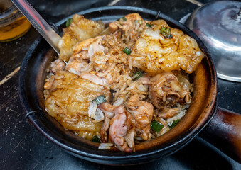 Clay pot rice meal with pieces of chicken, herbs and special sauce.